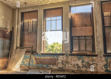 Un'auletta scuola in un abbandono della scuola di Detroit. Le finestre sono rotte e parzialmente imbarcati verso l'alto. Foto Stock