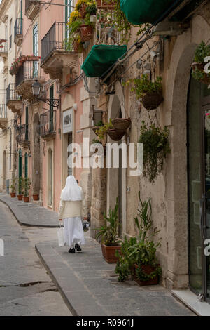 Una suora camminando giù per una strada in provincia di Siracusa Foto Stock