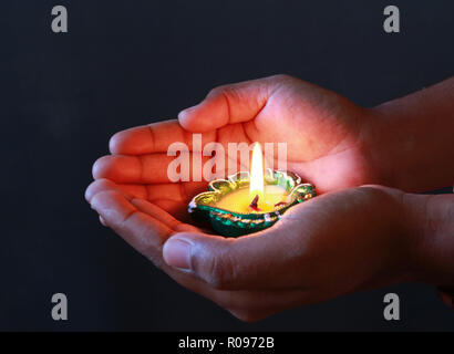 Una ragazza tenendo accesa diya nella sua mano per festeggiare il Diwali e dhanteras Foto Stock