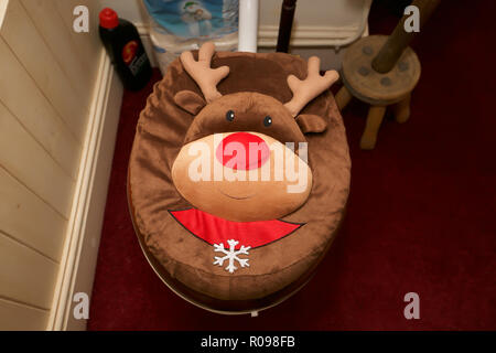 Imbottitura di rudolph il naso rosso renne sedile di gabinetto coperchio nel bagno del treno presso la hall a Abbey-Cwm-hir Foto Stock