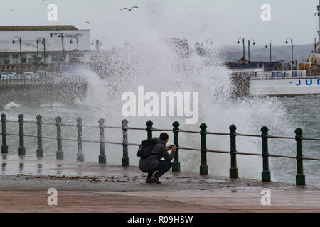 Penzance, Cornwall, Regno Unito. Il 3 novembre 2018. Regno Unito Meteo. Come Oscar tempesta si avvicina al Regno Unito e grandi onde hit Penzance fronte mare questo giovane erano di fronte al mare a fotografare le onde. Credito: Simon Maycock/Alamy Live News Foto Stock