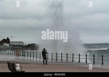 Penzance, Cornwall, Regno Unito. Il 3 novembre 2018. Regno Unito Meteo. Come Oscar tempesta si avvicina al Regno Unito e grandi onde hit Penzance fronte mare questo giovane erano di fronte al mare a fotografare le onde. Credito: Simon Maycock/Alamy Live News Foto Stock