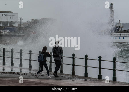 Penzance, Cornwall, Regno Unito. Il 3 novembre 2018. Regno Unito Meteo. Come Oscar tempesta si avvicina al Regno Unito e grandi onde hit Penzance fronte mare questo giovane erano di fronte al mare a fotografare le onde. Credito: Simon Maycock/Alamy Live News Foto Stock