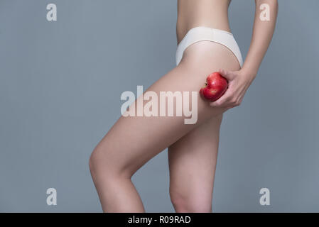 Varie espressione da ragazza giovane con apple frutta fresca su sfondo neutro Foto Stock