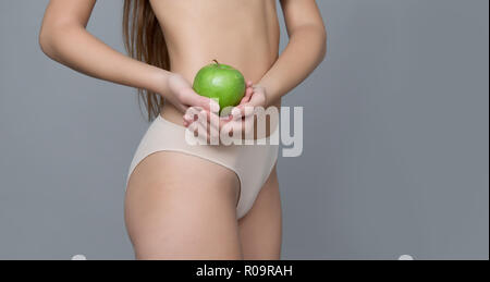 Varie espressione da ragazza giovane con apple frutta fresca su sfondo neutro Foto Stock