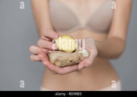 Varie espressione da ragazza giovane con lo zenzero frutta fresca su sfondo neutro Foto Stock