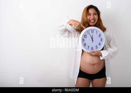 Ritratto di giovane e bella incinta donna asiatica holding orologio Foto Stock