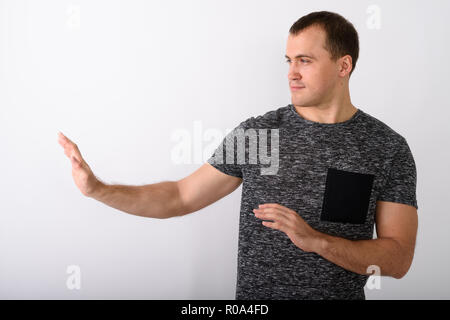 Vista di profilo del giovane uomo muscolare che mostra la mano di arresto segno per il Foto Stock