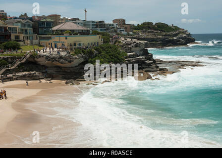 Vista lungo la spiaggia di Tamarama foreshore dalla passeggiata costiera con spiagge dorate, mare turchese e surf. Sydney Australia. Foto Stock