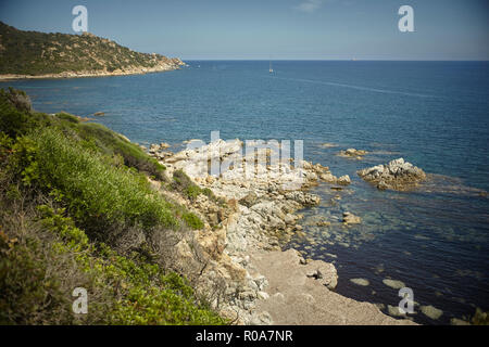 Insenatura naturale tra le montagne e il mare nel sud della Sardegna con il contorno di una vegetazione tipica della macchia mediterranea che cresce spontanea Foto Stock