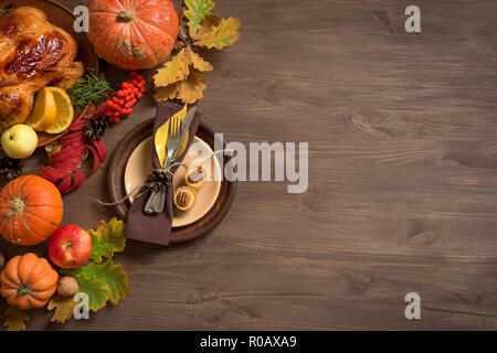 Cena di ringraziamento lo sfondo con la Turchia, zucche, cadono le foglie, messa in tavola e decorazioni stagionali, vista dall'alto, copia dello spazio. Foto Stock