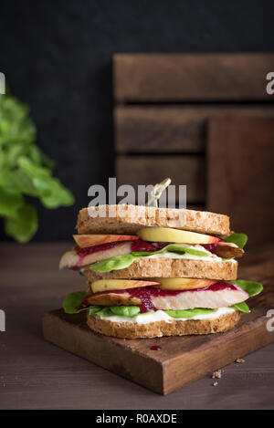 La Turchia o pollo avanzi di sandwich con ripieno e salsa di mirtilli. Appena sfornati dal giorno del Ringraziamento o tacchino di Natale gli avanzi sul crusty wholemea Foto Stock