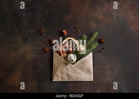 Composizione di Natale con le spezie, ramo di abete e vintage avvolgono, piatto laici scuro su sfondo rustico, copia dello spazio. Natale biglietto di auguri, design, co Foto Stock