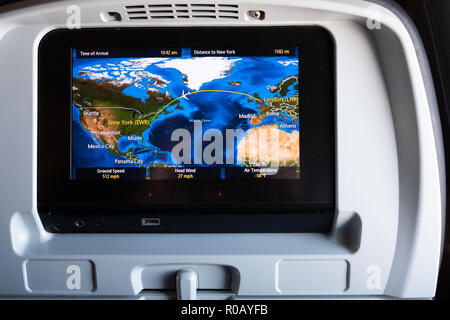 Uno schermo dello schienale su un aereo che mostra la posizione del volo su un volo a lunga percorrenza da Londra a New York USA. Un sistema di intrattenimento in volo o IFE Foto Stock