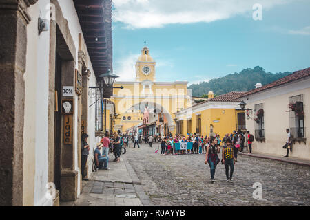 La folla raccolta per scattare foto intorno al famoso segno distintivo giallo Arco di Santa Catalina in Antigua Guatemala Foto Stock