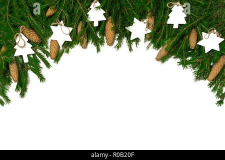 Ampio arco di confine di Natale isolato su bianco, composta di fresco rami di abete, coni e decorazioni in legno Foto Stock