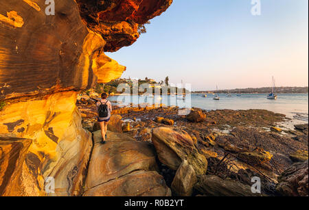 Una donna che cammina lungo il Romitorio Foreshore via alla Baia di Eremita nella Vaucluse. Sydney, Australia Foto Stock