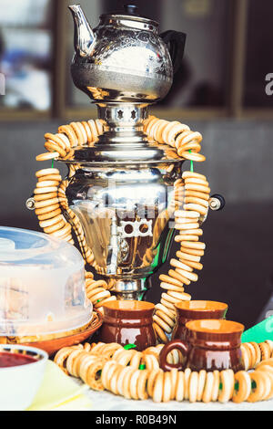 Metallica samovar russo con una teiera sulla parte superiore con bagel su di esso Foto Stock
