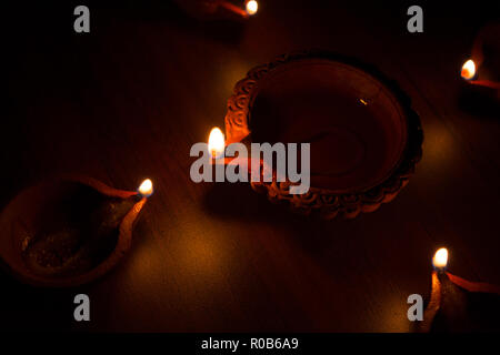 Diwali diyas terracotta su sfondo scuro che vengono utilizzati l'illuminazione della casa durante il Diwali volte Foto Stock