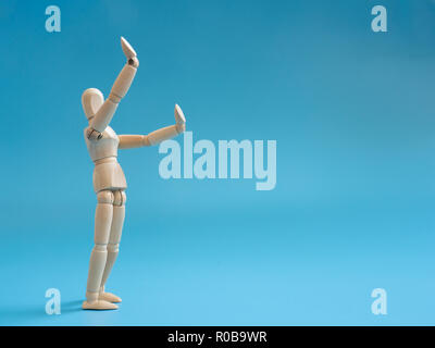 Legno Puppet sollevare le mani in aria per permette qualcosa in aria. Gambe di standing burattini in legno. Foto Stock