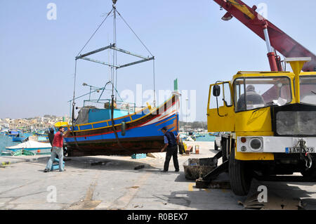 Intorno a Malta - il tradizionale maltese Luzzu viene portato a terra per le riparazioni Foto Stock