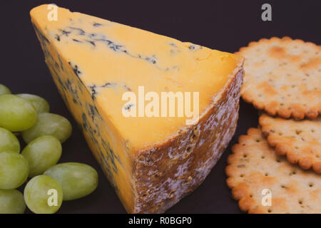 Un cuneo di Shropshire Blue Cheese con cracker e uva Foto Stock