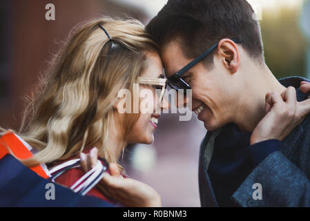 Immagine che mostra la coppia giovane di shopping in citta'. Ritratto di un giovane con borse per lo shopping in città.la gente, la vendita, l'amore e la felicità del concetto. Foto Stock