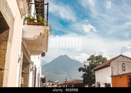 Colorate strade di Antigua Guatemala conducono verso la Volcan de Agua Vulcano su un giorno d'estate Foto Stock