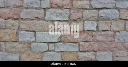 Texture irregolare di un colorato un muro di mattoni. Foto Stock