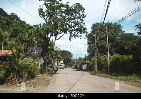 Polverosa strada principale attraverso la cittadina di Santa Teresa, sulla costa del pacifico della penisola di Nicoya, Costa Rica Foto Stock