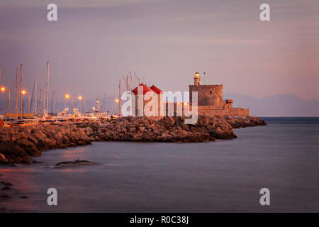 Mulini a vento e il faro fortificato sul molo del porto. La città di Rodi, Grecia. Foto Stock
