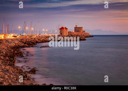 Il mulino a vento e il faro fortificato nella città di Rodi marina molo. Foto Stock