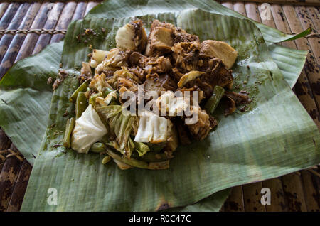 Siomay - piatto indonesiano con pesce al vapore di gnocco e verdure serviti in salsa di arachidi in banana leaf Foto Stock