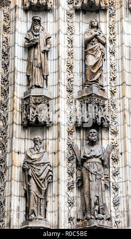 Sevilla, Spagna - 9 Settembre 2017: dettaglio delle statue di santi scolpiti nella pietra alla porta dell'Assunzione della cattedrale di Siviglia, Spagna Foto Stock