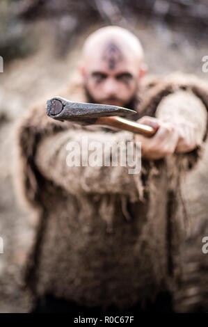 Un maschio di viking carattere ispirato in montagna. Modello reale che indossa la pelliccia e portante un ax Foto Stock