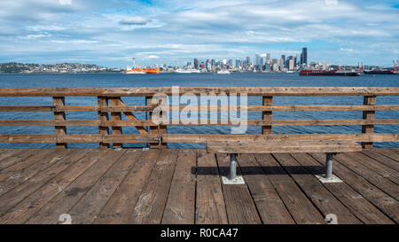 Panca in legno sul molo di legno con il centro cittadino di Seattle in background Foto Stock