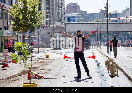 Manifestante maschio tenendo una vernice spray mostra segno di forza gesto su strada durante Gezi park proteste di Ankara, Turchia Foto Stock