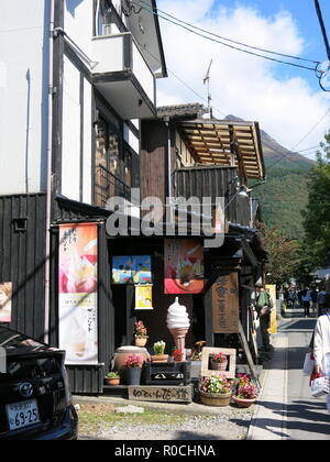 Una scena di strada nella popolare meta turistica di Yufuin, Giappone; un sacco di negozi di articoli da regalo e stradine pittoresche. Foto Stock