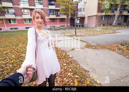 Giovane donna uomo di contenimento nella parte anteriore del edificio suburbano Foto Stock