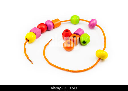 Perline di legno su una stringa facendo un giocattolo colorato collana Foto Stock