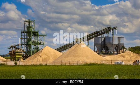 Costruzione di sabbia terminale di data mining con nastri trasportatori e silos su un offuscato giorno di estate Foto Stock