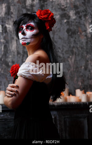 Foto di zombie donna con faccia bianca e fiore rosso sul suo capo Foto Stock