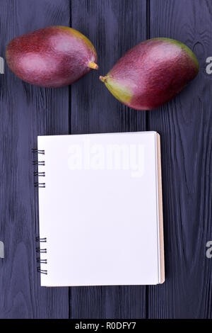 Frutti di mango e spirale vuota notepad. Foto Stock