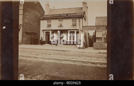 L'annata 1923 Cartolina fotografica che mostra una casa pubblica con un segno per Charrington bene Ales & Stout. Foto Stock