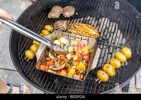 Verdure, patate e spiedini di carne su una griglia a carbone, terrazza, a mano e a pedale. Foto Stock