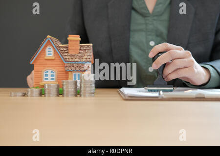 Real estate agent utilizzando stamper per la stampigliatura approvato il mutuo ipotecario contratto documento Foto Stock