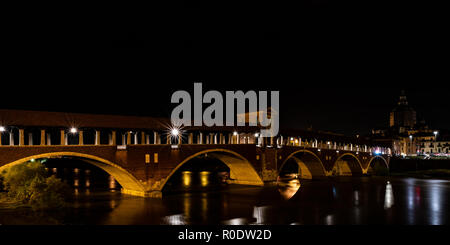 La fotografia notturna del Ponte Coperto di Pavia, edificio storico chiamato anche Ponte Vecchio costruito sul fiume Ticino. L'immagine orizzontale di Italiano Foto Stock