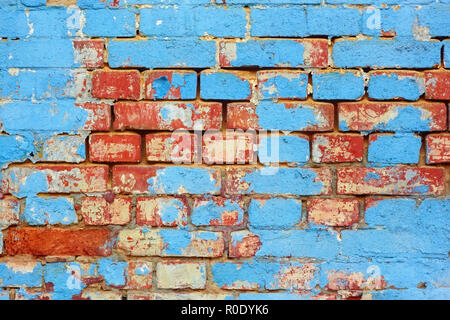 Frammento del vecchio muro in mattoni con blu sgusciate gli strati di vernice Foto Stock