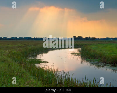 Sunray sono di rottura attraverso le nuvole sopra pianura riserva naturale Foto Stock