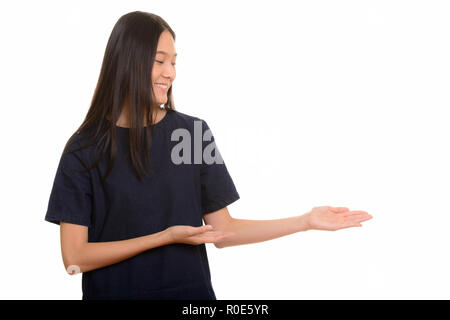 Giovani asiatici felice ragazza sorridente e mostrando qualcosa di Foto Stock